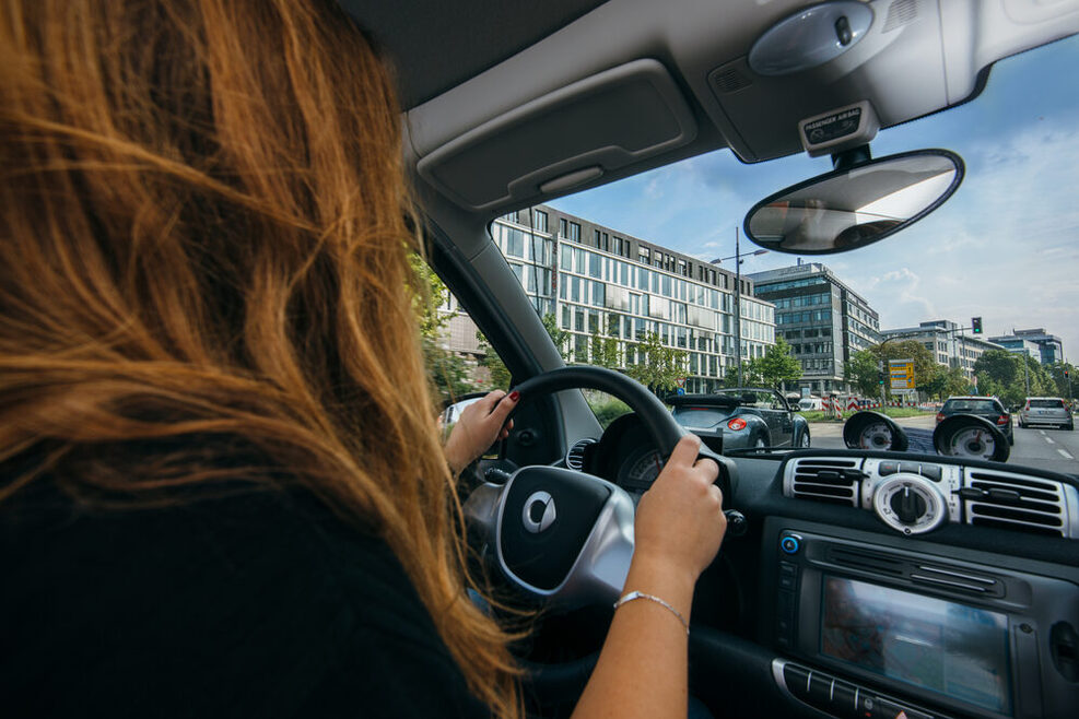 A Woman is driving in a car through Stuttgart.