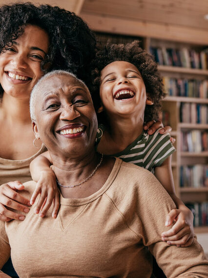 Three generations of woman smiling.
