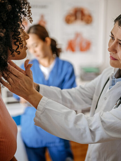 A doctor is checking the neck of a patient.